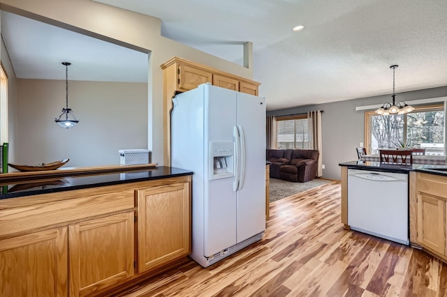 kitchen featuring a healthy amount of sunlight, dark countertops, and white appliances