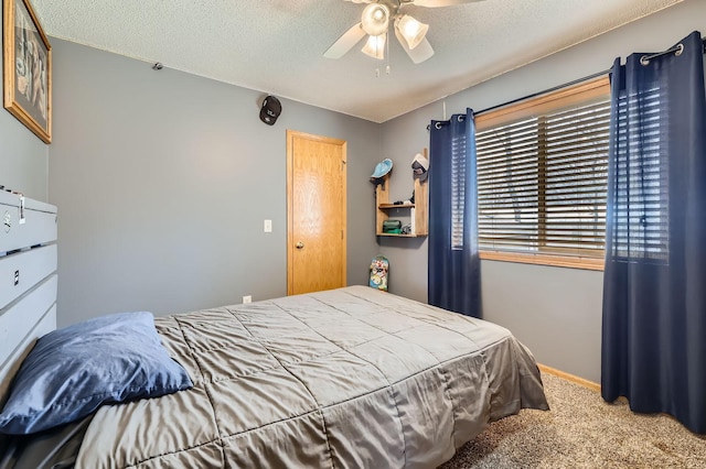 carpeted bedroom with a ceiling fan, a textured ceiling, and baseboards