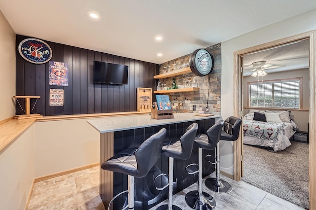 bar featuring wooden walls, recessed lighting, a ceiling fan, and bar