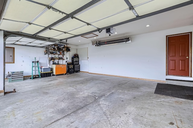 garage with baseboards, recessed lighting, a garage door opener, and electric panel