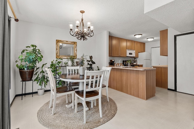 dining space featuring a chandelier, a textured ceiling, and light floors