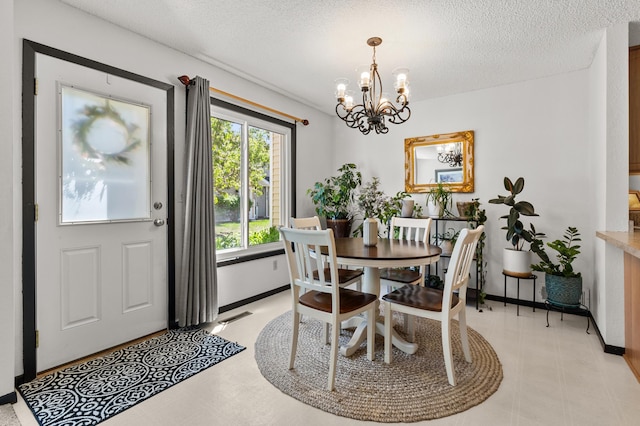 dining area featuring a chandelier, a textured ceiling, and baseboards