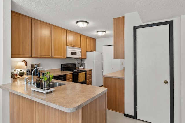 kitchen featuring white appliances, a sink, a peninsula, light countertops, and a textured ceiling