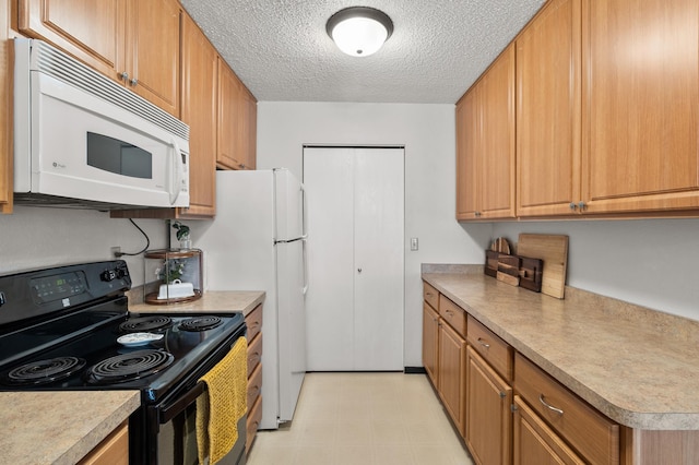 kitchen featuring black range with electric stovetop, white microwave, light floors, a textured ceiling, and light countertops