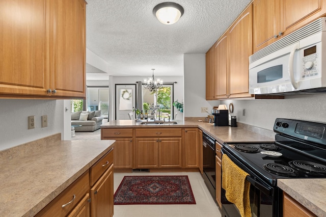 kitchen featuring black appliances, a sink, a chandelier, a peninsula, and a textured ceiling