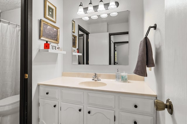 full bathroom featuring vanity, toilet, and a textured ceiling
