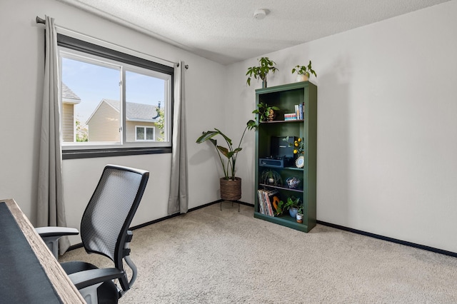 carpeted home office with a textured ceiling and baseboards