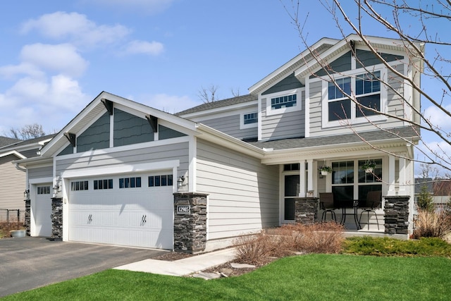 12985 Legacy Creek Pkwy NE, Blaine, MN 55449 - craftsman inspired home featuring covered porch, stone siding, an attached garage, asphalt driveway, and a shingled roof