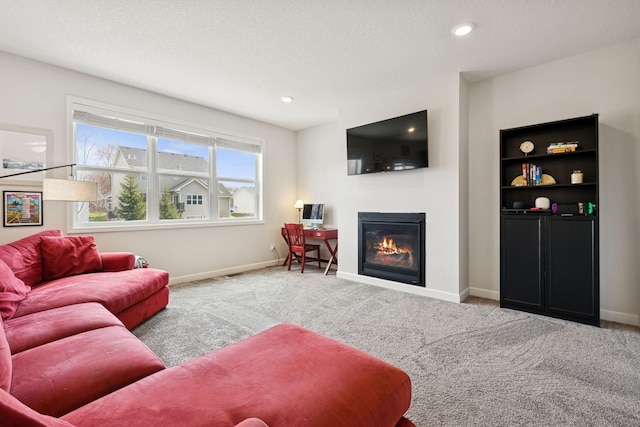 12985 Legacy Creek Pkwy NE, Blaine, MN 55449 - living room featuring a glass covered fireplace, carpet floors, baseboards, a textured ceiling, and recessed lighting