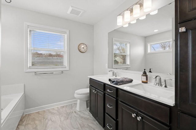 12985 Legacy Creek Pkwy NE, Blaine, MN 55449 - full bathroom featuring toilet, marble look tile flooring, a bath, baseboards, and double vanity