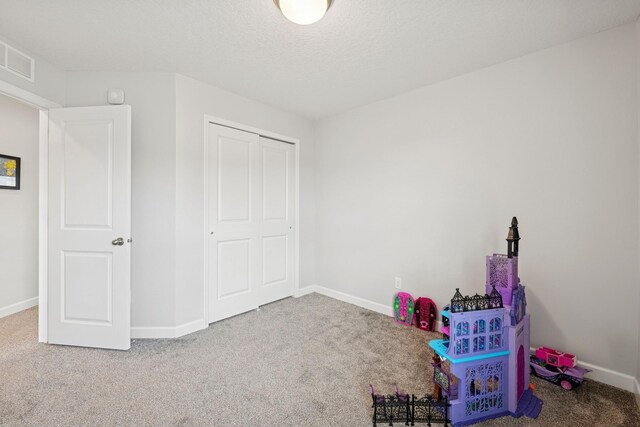 12985 Legacy Creek Pkwy NE, Blaine, MN 55449 - rec room with carpet flooring, baseboards, and a textured ceiling