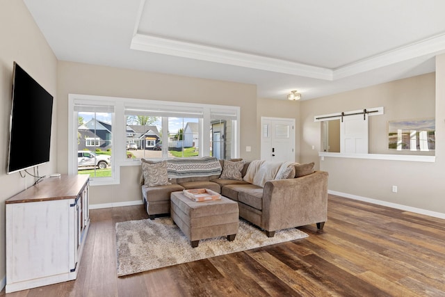 1302 Windrush Rd, Buffalo, MN 55313 - living room with a barn door, dark wood-style floors, a tray ceiling, crown molding, and baseboards