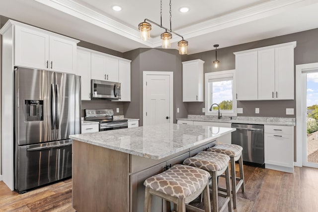 1302 Windrush Rd, Buffalo, MN 55313 - kitchen with stainless steel appliances, a center island, dark wood-type flooring, white cabinetry, and ornamental molding