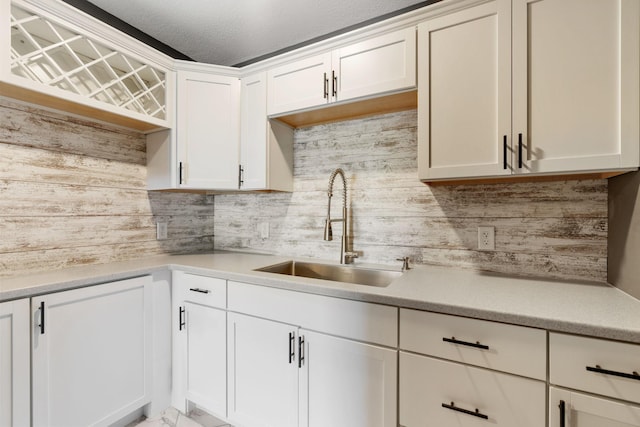 1302 Windrush Rd, Buffalo, MN 55313 - kitchen with a sink, decorative backsplash, light countertops, white cabinetry, and a textured ceiling