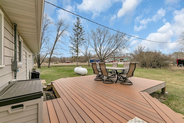 wooden terrace featuring a lawn and outdoor dining area