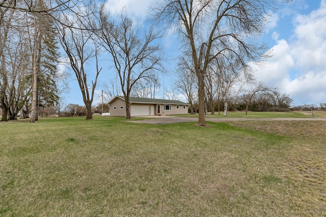 view of yard featuring an attached garage and driveway