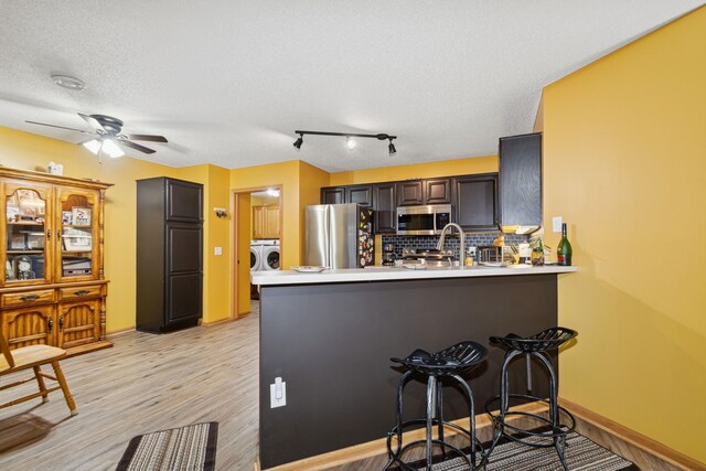 4674 Eagle Ridge Ln, Monticello, MN 55362 - kitchen with decorative backsplash, a peninsula, appliances with stainless steel finishes, and light countertops