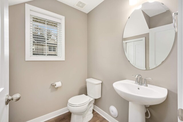 bathroom with visible vents, wood finished floors, a sink, baseboards, and toilet
