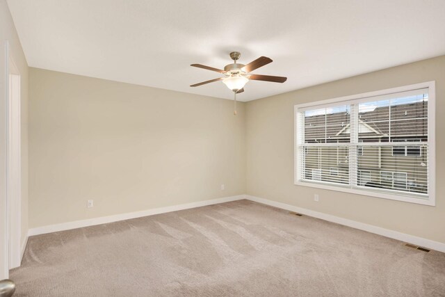 spare room with visible vents, baseboards, ceiling fan, and carpet floors