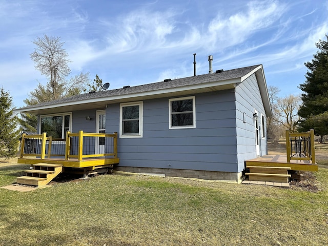 rear view of property with a wooden deck and a yard