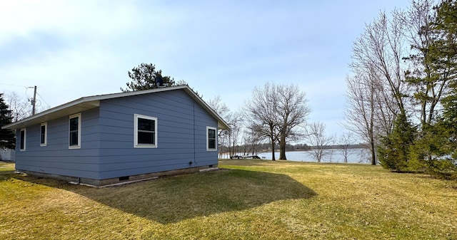 view of side of property featuring a lawn and a water view