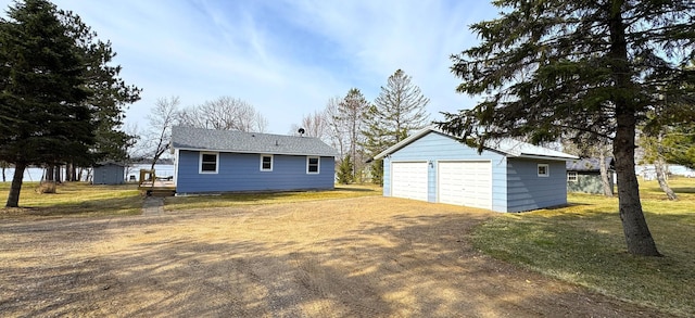 back of house with an outbuilding, a yard, and a detached garage