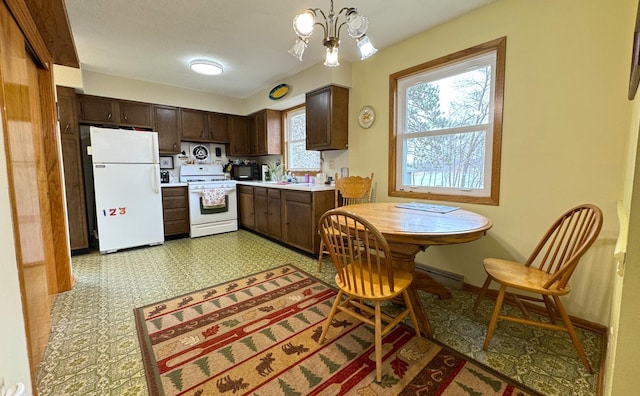 kitchen featuring dark brown cabinets, white appliances, light floors, light countertops, and decorative light fixtures