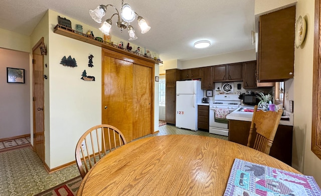 kitchen featuring a textured ceiling, dark brown cabinets, a chandelier, white appliances, and light countertops