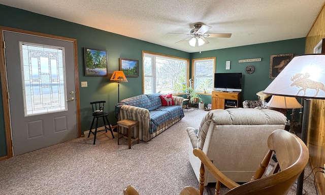 living area featuring carpet flooring, a textured ceiling, and ceiling fan