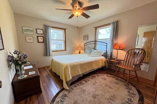 bedroom featuring wood finished floors, a textured ceiling, a ceiling fan, and baseboards