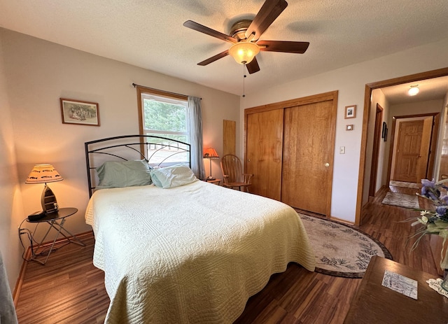 bedroom with a textured ceiling, baseboards, wood finished floors, a closet, and ceiling fan