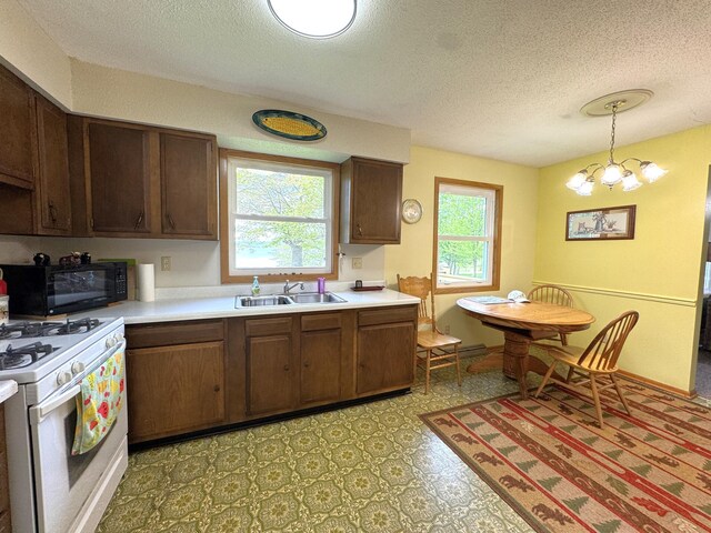 36777 311th Ln, Aitkin, MN 56431 - kitchen with white range with gas cooktop, a sink, black microwave, light countertops, and a textured ceiling