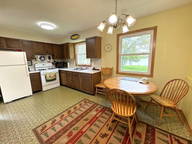 36777 311th Ln, Aitkin, MN 56431 - kitchen featuring white appliances, light countertops, a chandelier, a sink, and dark brown cabinets