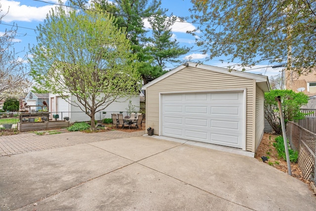detached garage with fence and driveway