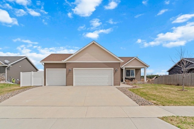 907 7th Ave, Wanamingo, MN 55983 - view of front facade featuring a garage, a front lawn, fence, and driveway