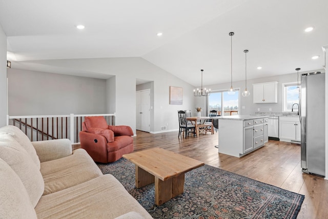 907 7th Ave, Wanamingo, MN 55983 - living room featuring light wood-style flooring, vaulted ceiling, a chandelier, recessed lighting, and baseboards