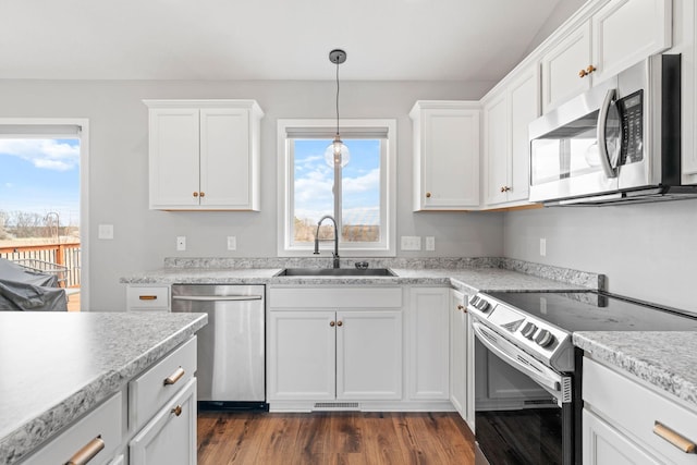 907 7th Ave, Wanamingo, MN 55983 - kitchen featuring stainless steel appliances, a sink, white cabinets, and dark wood finished floors