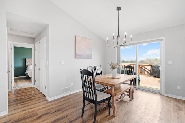 907 7th Ave, Wanamingo, MN 55983 - dining space with wood finished floors, a chandelier, baseboards, and vaulted ceiling