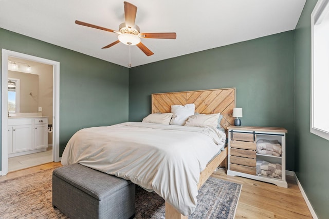 907 7th Ave, Wanamingo, MN 55983 - bedroom featuring wood finished floors, connected bathroom, baseboards, and a ceiling fan
