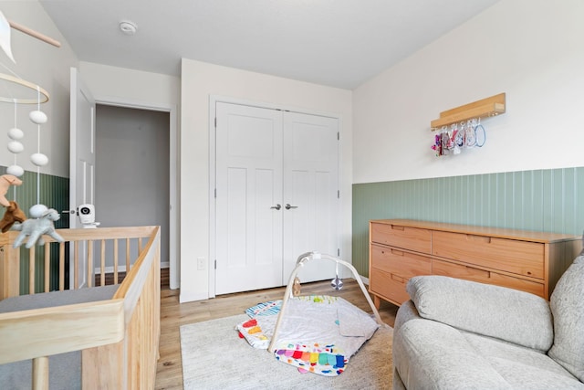 907 7th Ave, Wanamingo, MN 55983 - bedroom featuring wood finished floors, wainscoting, a closet, and baseboards