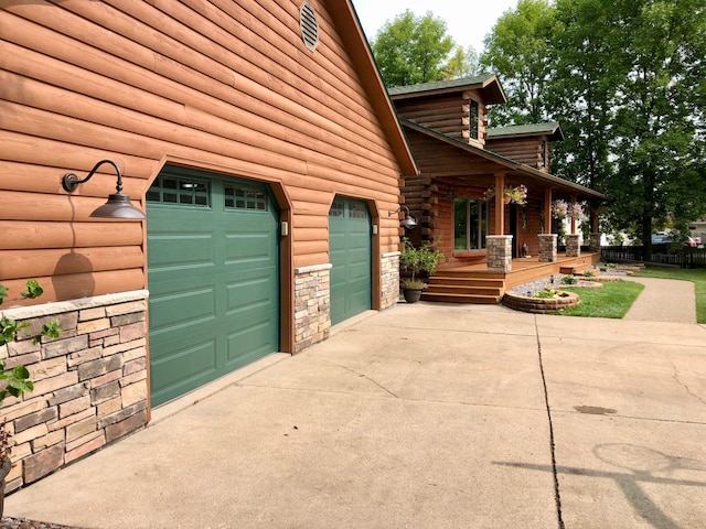 631 Pheasant Run, Winsted, MN 55395 - view of side of property featuring a porch, concrete driveway, a garage, and stone siding