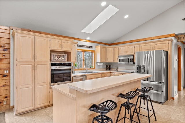 631 Pheasant Run, Winsted, MN 55395 - kitchen featuring stainless steel appliances, light brown cabinetry, a sink, vaulted ceiling, and a skylight