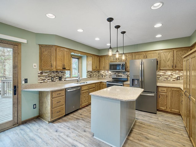 kitchen featuring light wood-style floors, tasteful backsplash, appliances with stainless steel finishes, and a sink