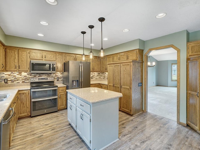 kitchen featuring recessed lighting, a kitchen island, light wood-style floors, and appliances with stainless steel finishes