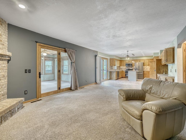 living room featuring a textured ceiling, baseboards, light carpet, and visible vents