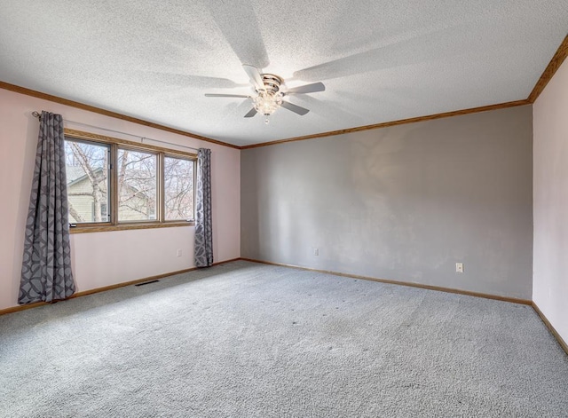 carpeted empty room featuring a ceiling fan, crown molding, a textured ceiling, baseboards, and visible vents
