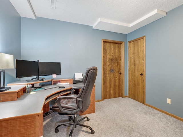carpeted office featuring a textured ceiling and baseboards