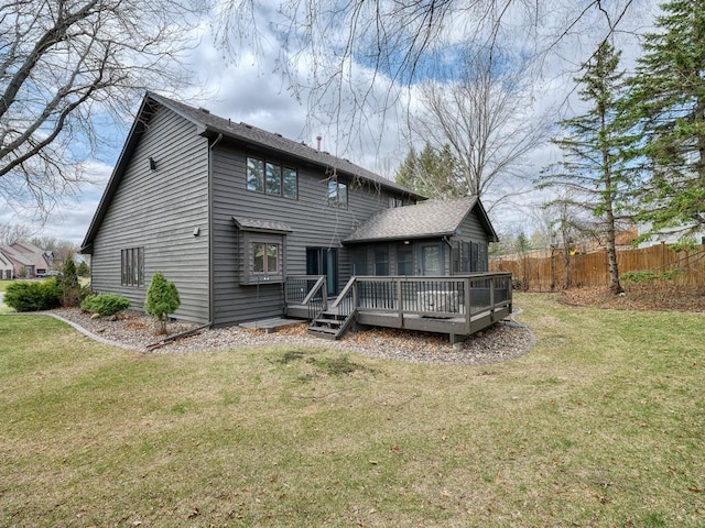 back of house with a wooden deck, a yard, and fence
