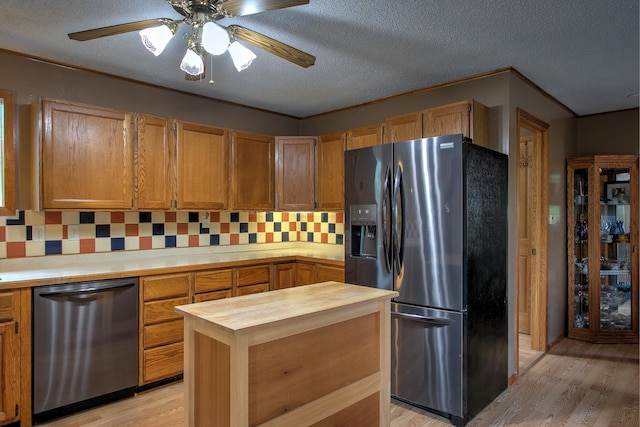 895 334th Ave NE, Cambridge, MN 55008 - kitchen with stainless steel appliances, butcher block countertops, light wood-style flooring, decorative backsplash, and a textured ceiling