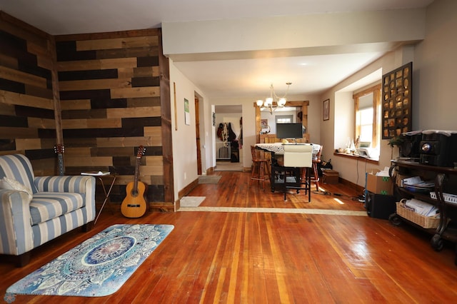 living area featuring hardwood / wood-style floors, baseboards, a chandelier, and radiator